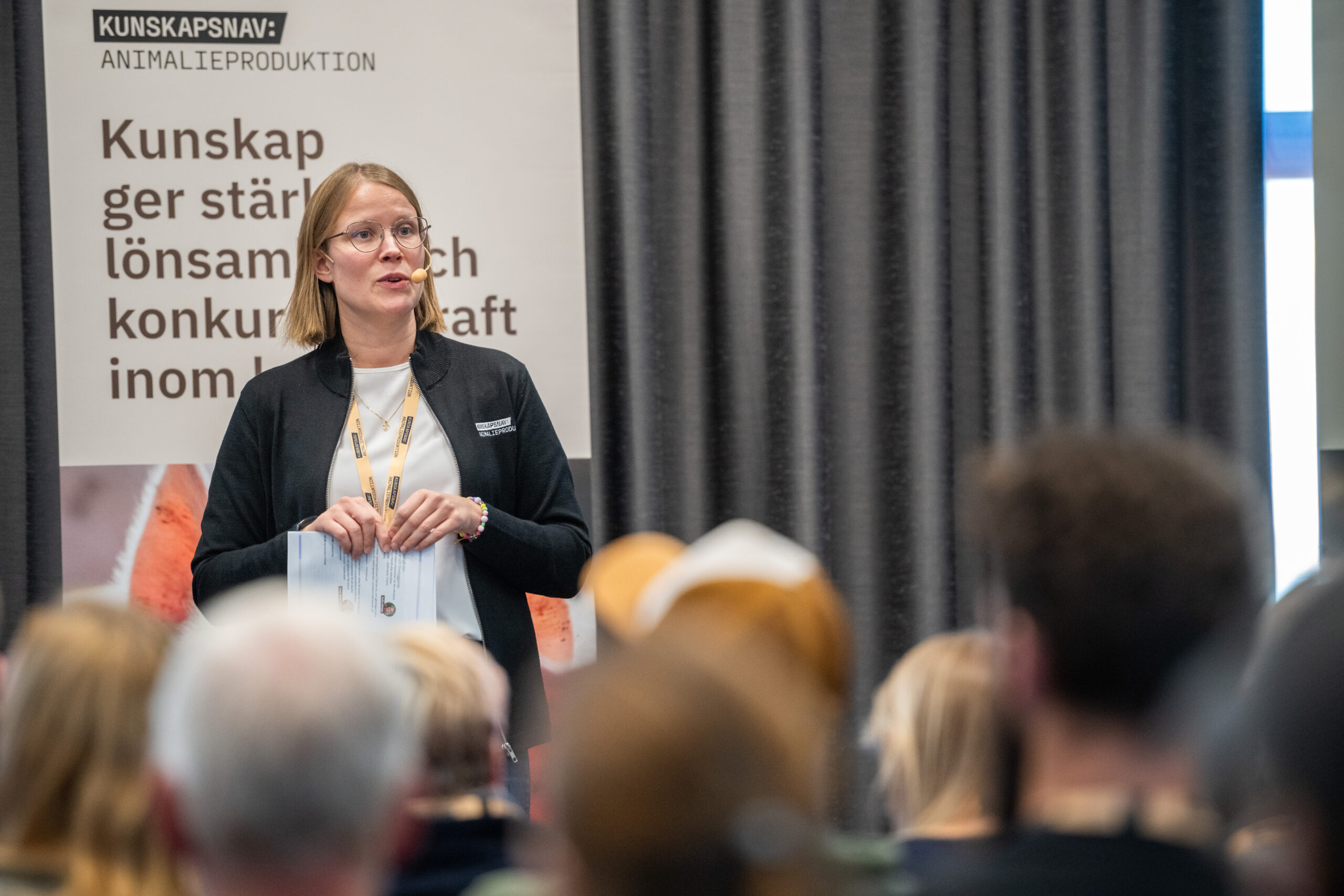 Person står på en scen och pratar inför en publik
